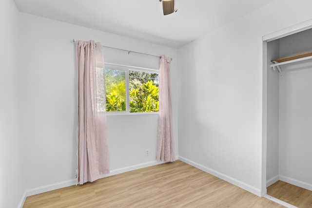 unfurnished bedroom with ceiling fan, light hardwood / wood-style floors, and a closet