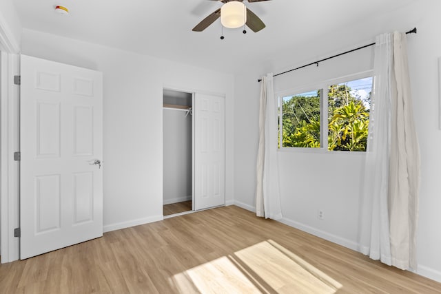 unfurnished bedroom with ceiling fan, light wood-type flooring, and a closet