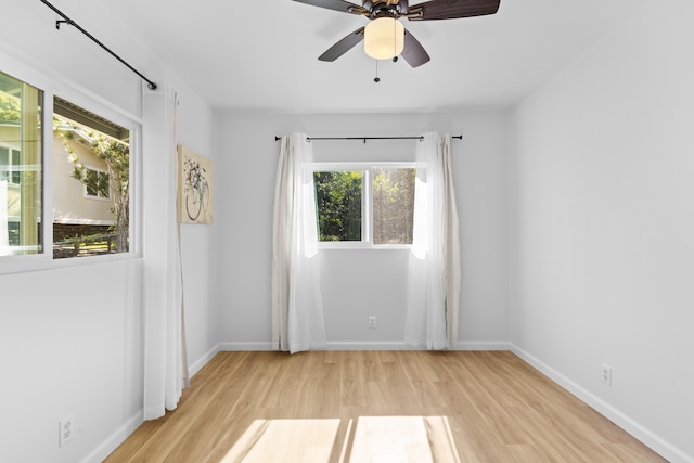 empty room with plenty of natural light, ceiling fan, and light hardwood / wood-style flooring