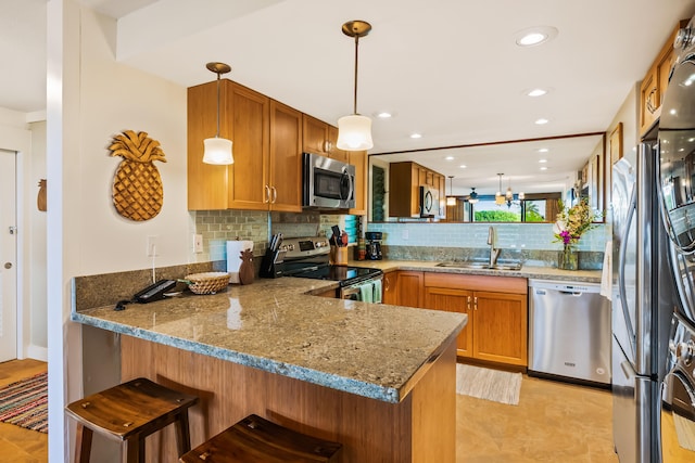 kitchen featuring kitchen peninsula, sink, hanging light fixtures, and appliances with stainless steel finishes