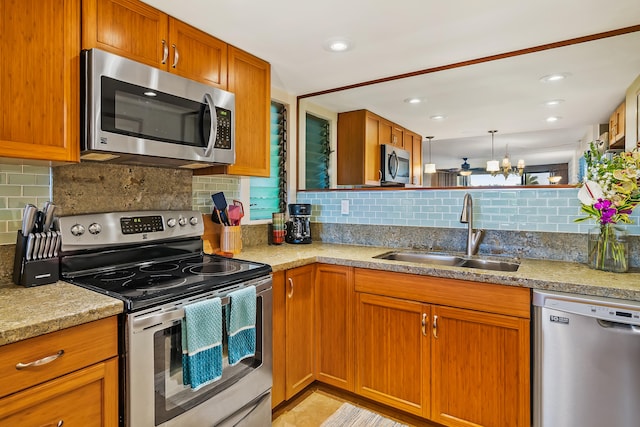 kitchen featuring decorative backsplash, light stone countertops, stainless steel appliances, sink, and an inviting chandelier