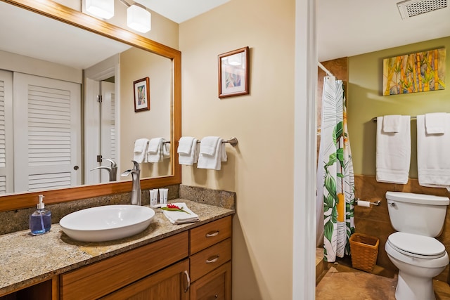 bathroom featuring curtained shower, vanity, and toilet