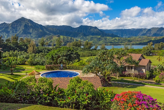 view of pool featuring a lawn and a water and mountain view