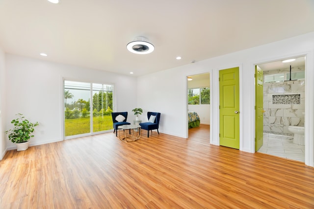 living area with light wood-type flooring and tile walls