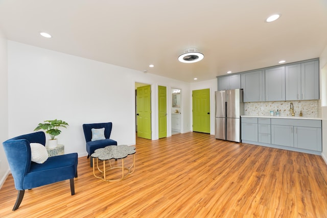 living area featuring light hardwood / wood-style flooring and sink