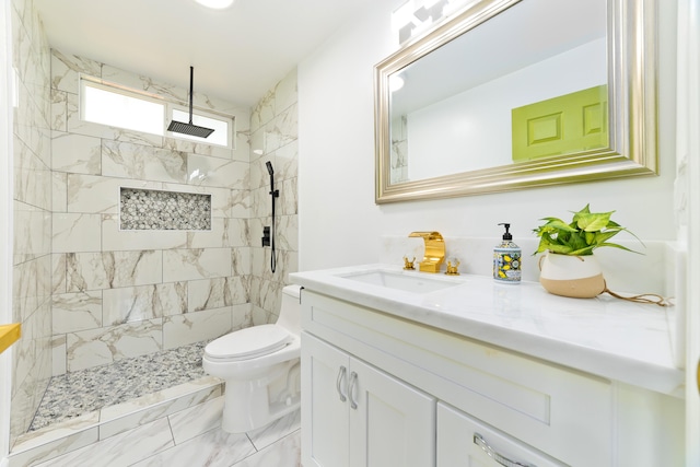 bathroom with vanity, toilet, and a tile shower