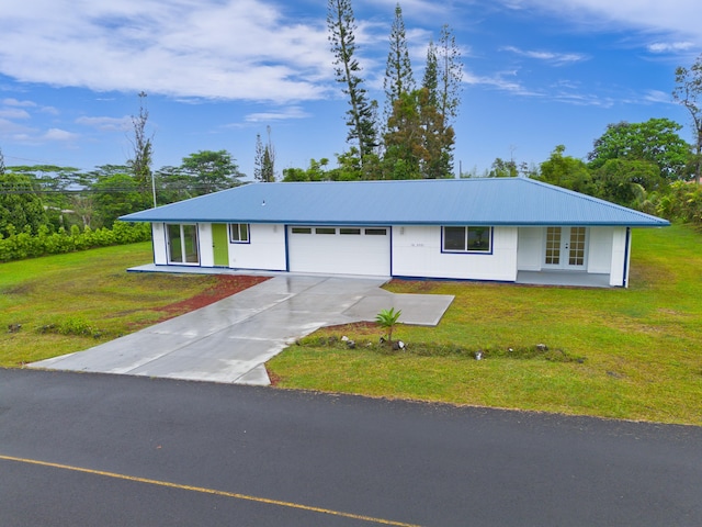 single story home with a front yard, french doors, and a garage