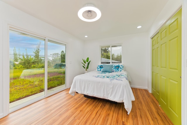 bedroom featuring access to exterior and hardwood / wood-style floors