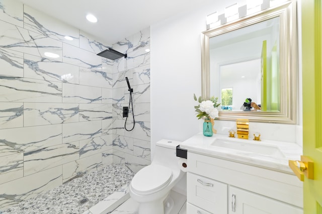 bathroom featuring toilet, vanity, and tiled shower