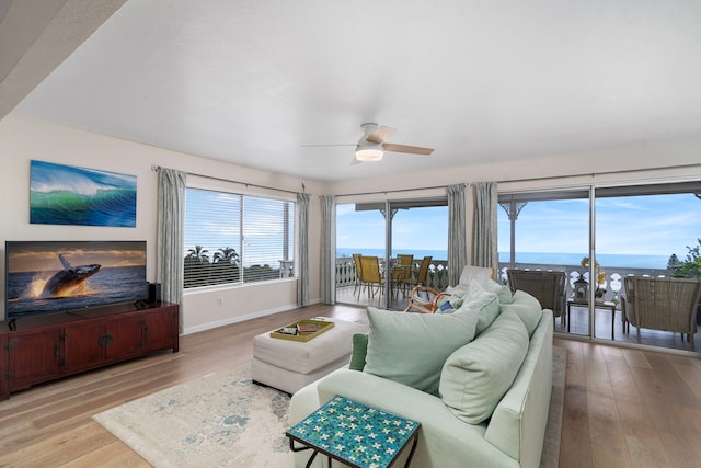 living room featuring a water view, light hardwood / wood-style flooring, and ceiling fan