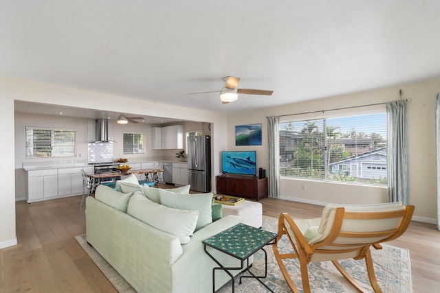 living room featuring ceiling fan and light hardwood / wood-style flooring