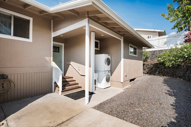 property entrance with stacked washer and dryer and a patio