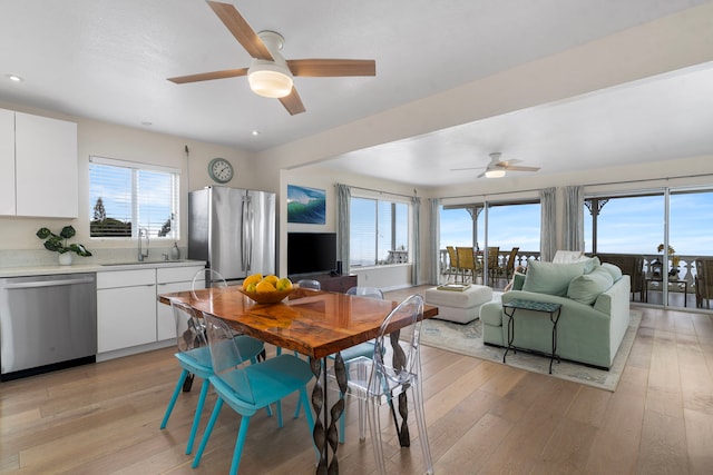 dining area featuring a wealth of natural light, sink, and light hardwood / wood-style flooring