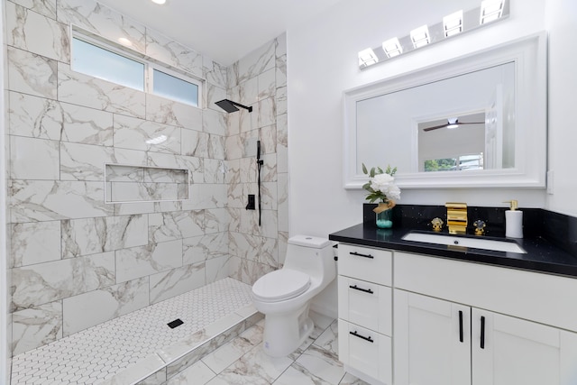 bathroom with toilet, a tile shower, and vanity