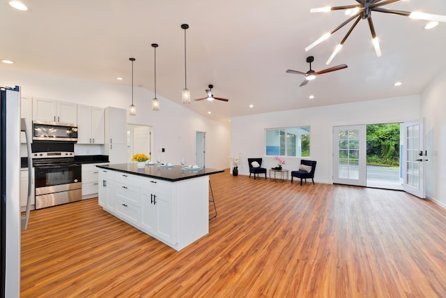 kitchen featuring pendant lighting, a center island, stainless steel appliances, and white cabinetry