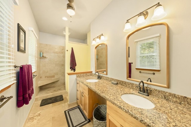 bathroom with a tile shower, ceiling fan, and vanity