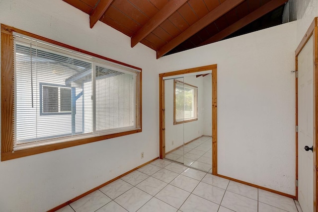 tiled empty room featuring vaulted ceiling with beams and wooden ceiling