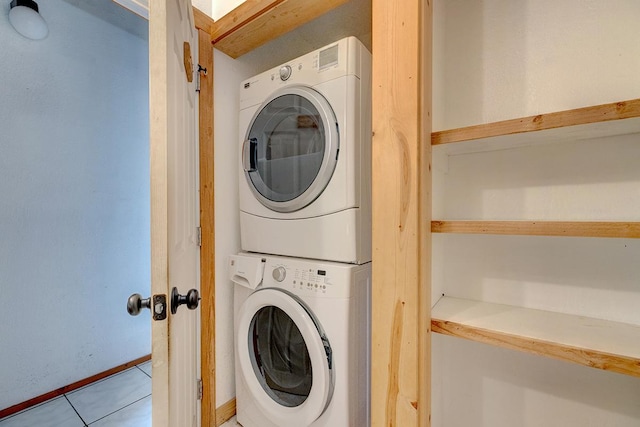 laundry room with light tile patterned floors and stacked washer and dryer