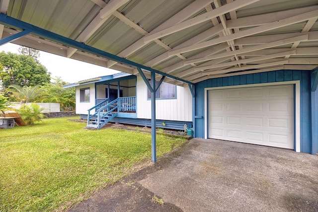 garage with covered porch and a yard