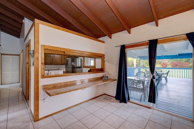 kitchen featuring stainless steel refrigerator, wooden ceiling, vaulted ceiling with beams, kitchen peninsula, and light tile patterned flooring