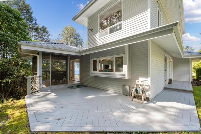 back of house featuring a sunroom and a deck