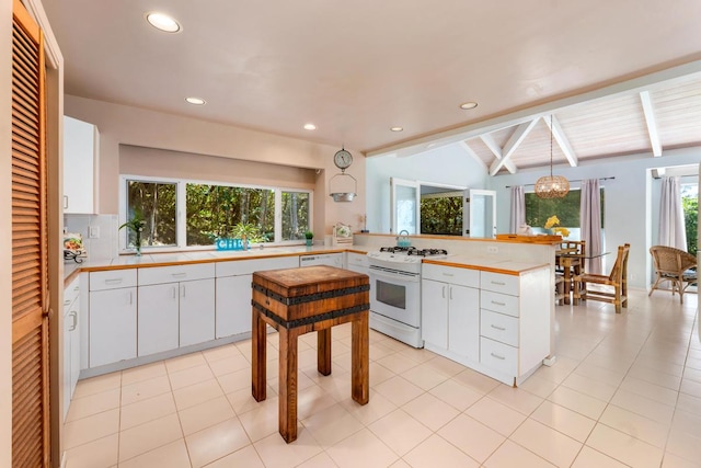 kitchen featuring a wealth of natural light, white appliances, pendant lighting, white cabinets, and vaulted ceiling with beams