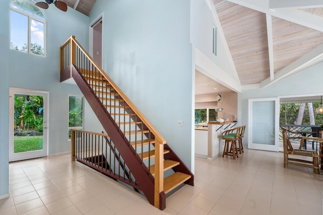 stairs featuring a healthy amount of sunlight, wooden ceiling, and high vaulted ceiling