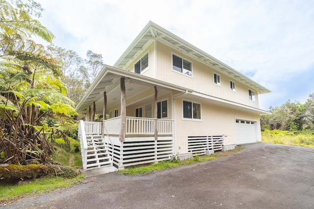 view of property exterior with covered porch and a garage