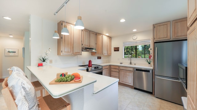 kitchen with kitchen peninsula, appliances with stainless steel finishes, and light brown cabinetry