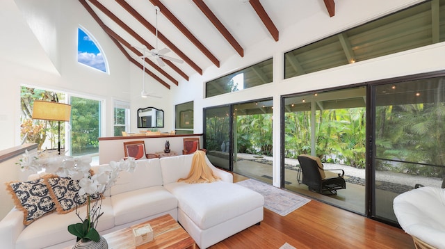 sunroom with ceiling fan and lofted ceiling with beams