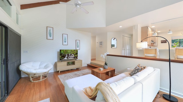 living room featuring beamed ceiling, hardwood / wood-style flooring, high vaulted ceiling, and ceiling fan