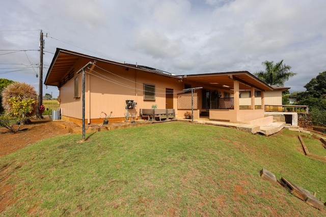 rear view of property featuring central AC unit and a lawn