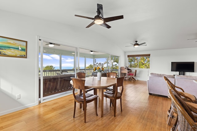 dining area with light hardwood / wood-style flooring and vaulted ceiling