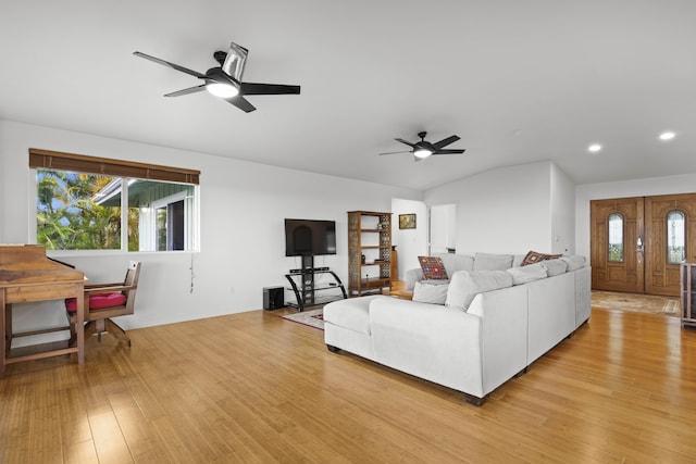 living room with ceiling fan, vaulted ceiling, a healthy amount of sunlight, and light wood-type flooring