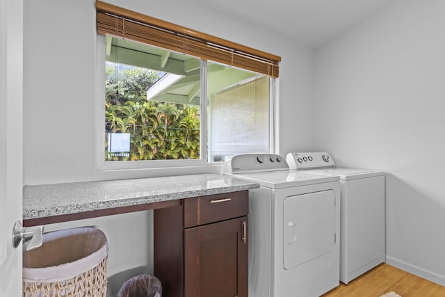 clothes washing area with plenty of natural light, separate washer and dryer, and light hardwood / wood-style flooring