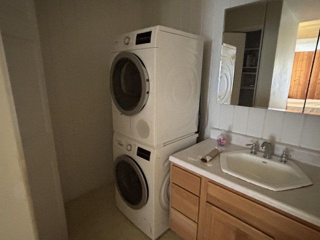 laundry area featuring stacked washer / dryer and sink