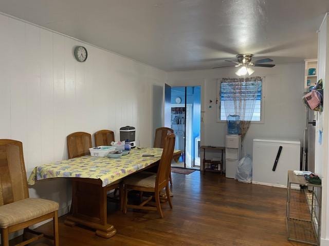 dining space with ceiling fan and dark wood-type flooring