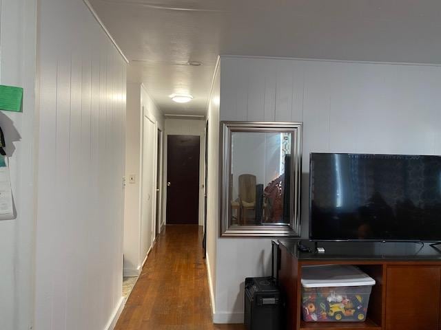 corridor featuring wood-type flooring and wood walls