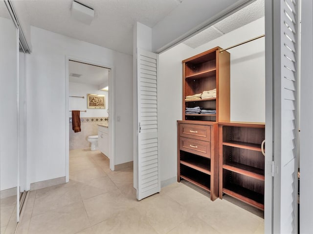 walk in closet with light tile patterned flooring