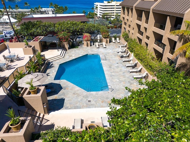 view of swimming pool with a patio and a water view