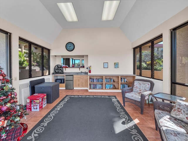 rec room with light tile patterned floors, vaulted ceiling, and sink