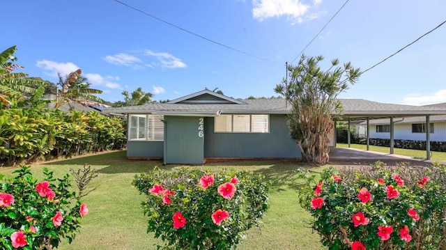 rear view of house featuring a lawn and a carport