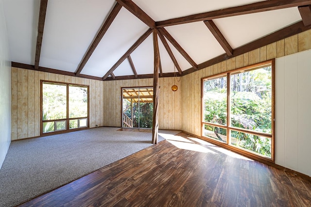 unfurnished living room with carpet flooring and vaulted ceiling with beams