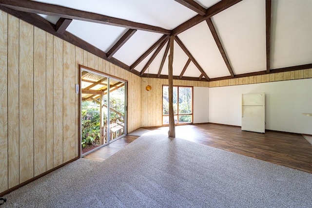 unfurnished room featuring vaulted ceiling with beams and hardwood / wood-style floors