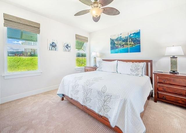 carpeted bedroom featuring multiple windows and ceiling fan