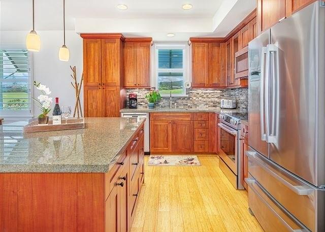 kitchen with hanging light fixtures, light stone counters, light hardwood / wood-style flooring, backsplash, and appliances with stainless steel finishes