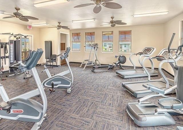 exercise room with ceiling fan and carpet floors