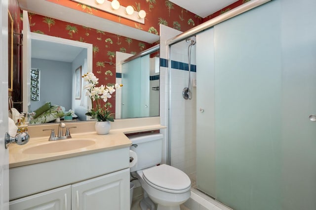 bathroom featuring vanity, toilet, and a shower with shower door