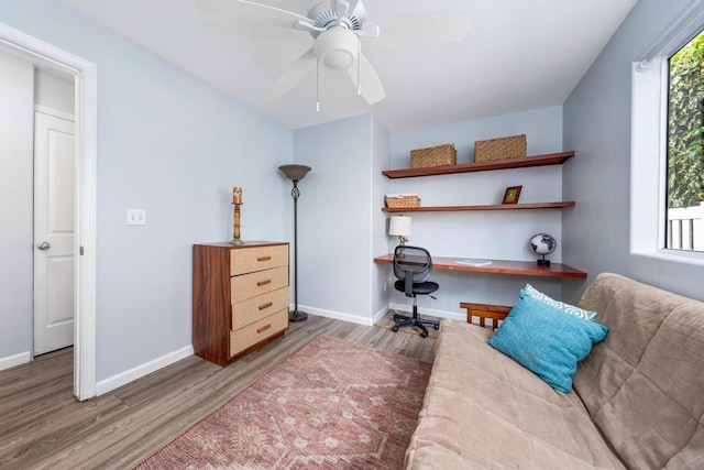 home office with hardwood / wood-style flooring, ceiling fan, and built in desk