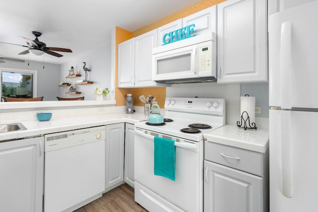 kitchen with white cabinets, white appliances, and tile countertops